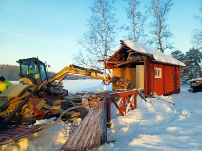 Kauhakuormaaja purkaa vanhaa rakennusta Lehtisaaressa. 